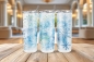 Preview: Drei Thermobecher mit einem eleganten blau-weißem Schneeflocken-Design, präsentiert auf einem Holztisch vor einem stilvollen Raum im Hintergrund. Ideal für heiße und kalte Getränke, mit einem Fassungsvermögen von 590 ml und winterlicher Optik.